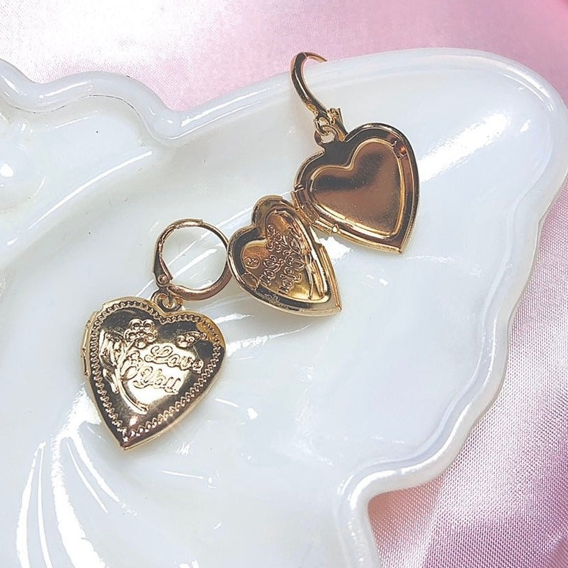 locket earrings shaped in a heart with "I love you" etched into surface on butterfly tray