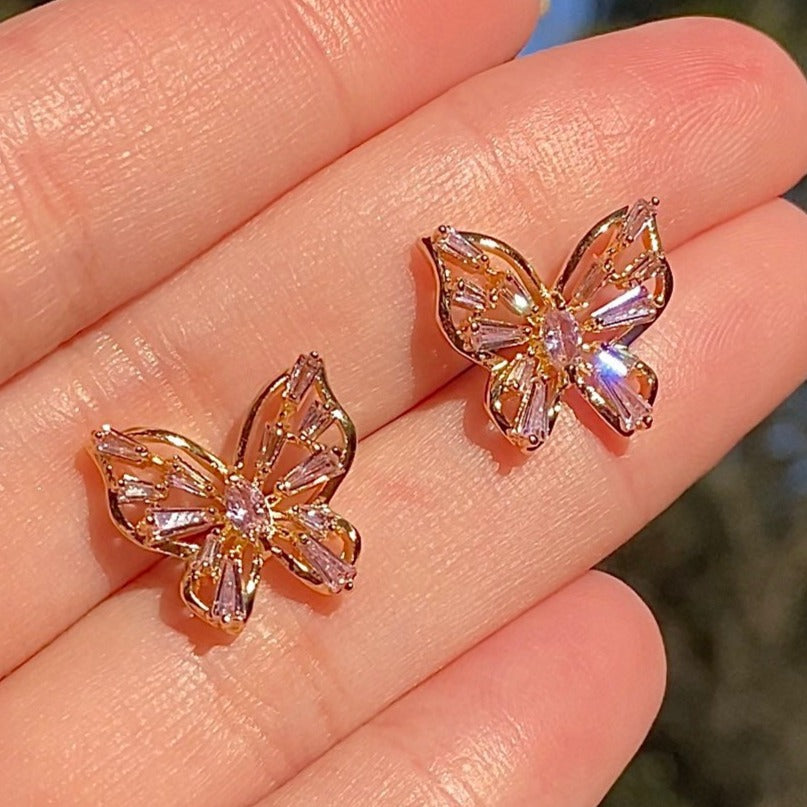 two cubic zirconia studs in a butterfly shape on hand