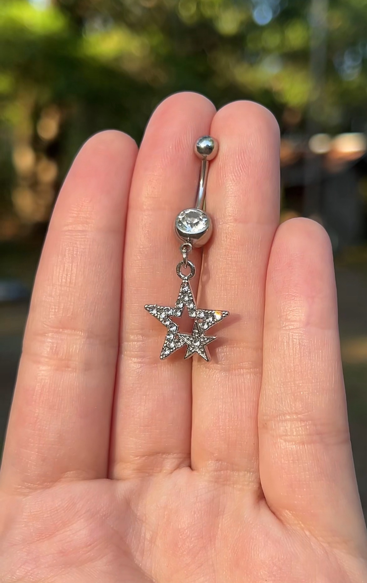 Silver star-shaped belly button ring y2k style