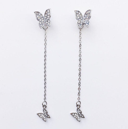 silver long drop earrings with two butterflies and a chain attachment on a white backgorund