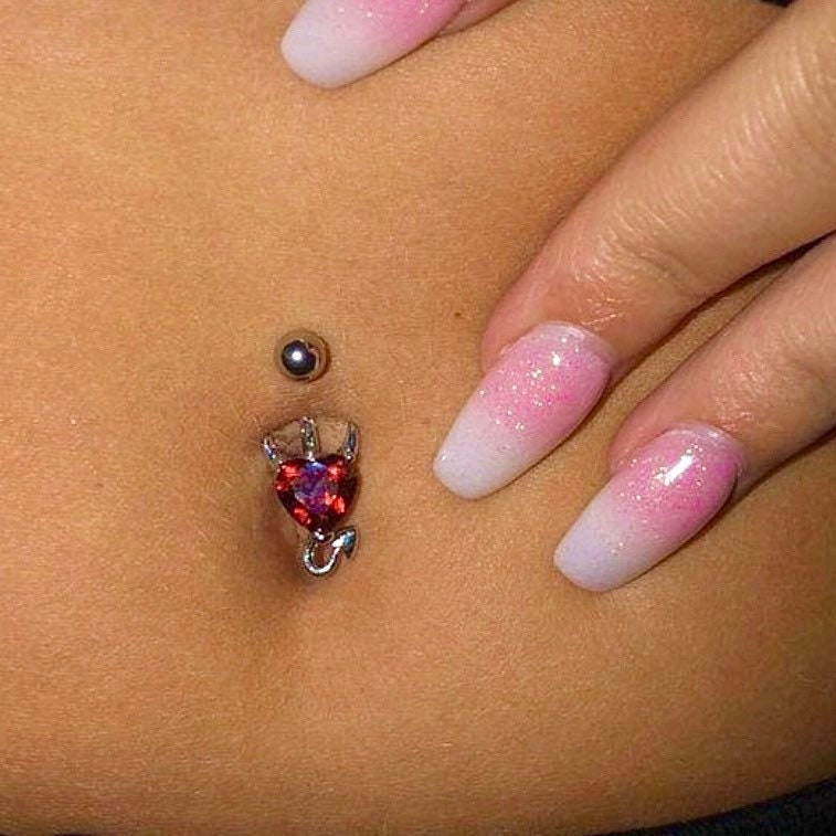closeup of red stone devil heart belly ring
