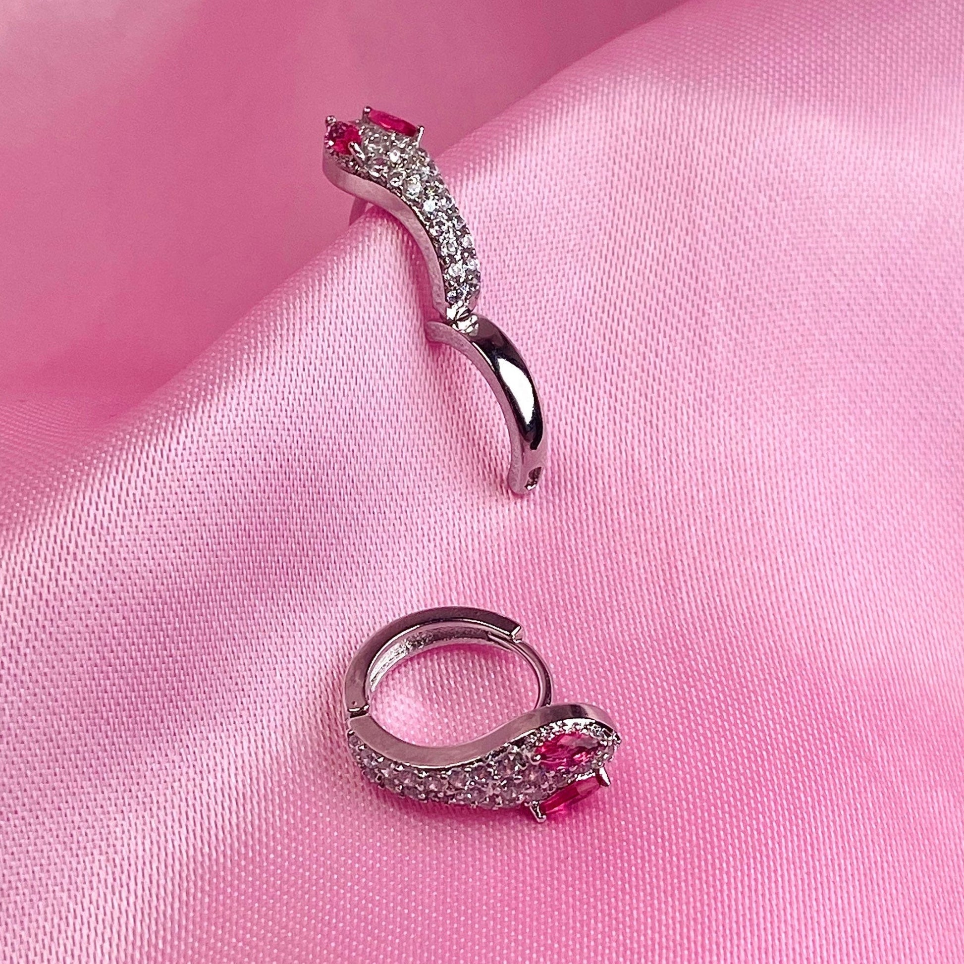 snake hoop style earrings with pink backdrop and in silver construction with pink eyeballs